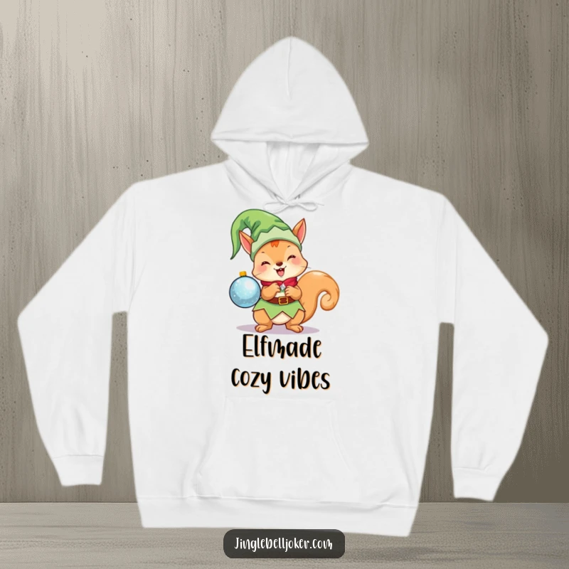 Funny Kawaii Elf Squirrel Hoodie: A cute Christmas character in an elf costume, excitedly holding a sparkling ornament, perfect for winter.