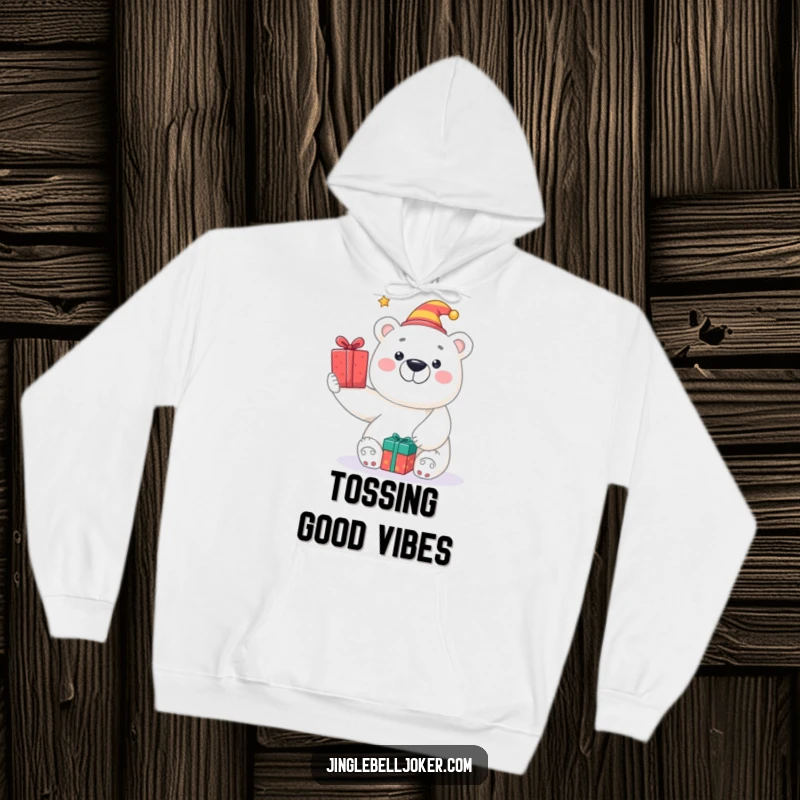 Funny hoodie depicting a smiling polar bear in a jester hat, tossing presents, ideal for warm and humorous winter days.