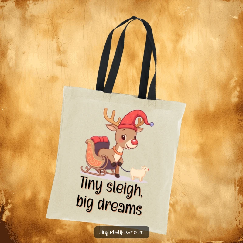 Funny tote bag depicting a brave reindeer in a jester hat, comically trying to pull a miniature sleigh, a humorous holiday accessory.
